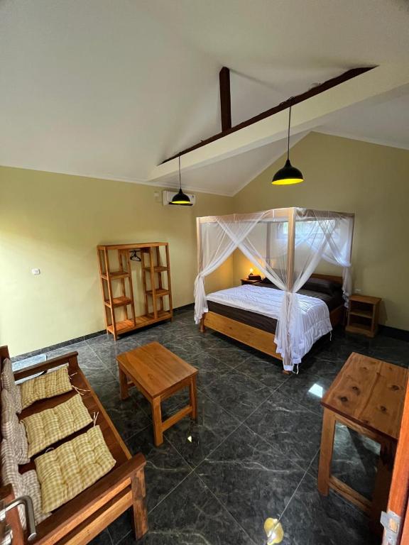 a bedroom with a bed and a table and chairs at Gifal Surf Camp & Cottage in Wainapal