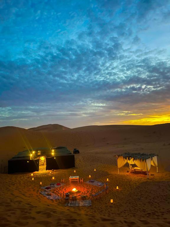 a group of tents in the desert at sunset at Nomada Desert Camp in Merzouga