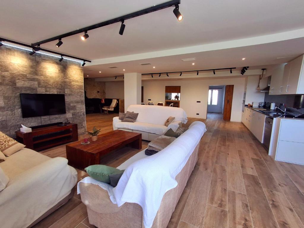 een woonkamer met twee banken en een keuken bij Can Pairot in Pujals dels Cavallers