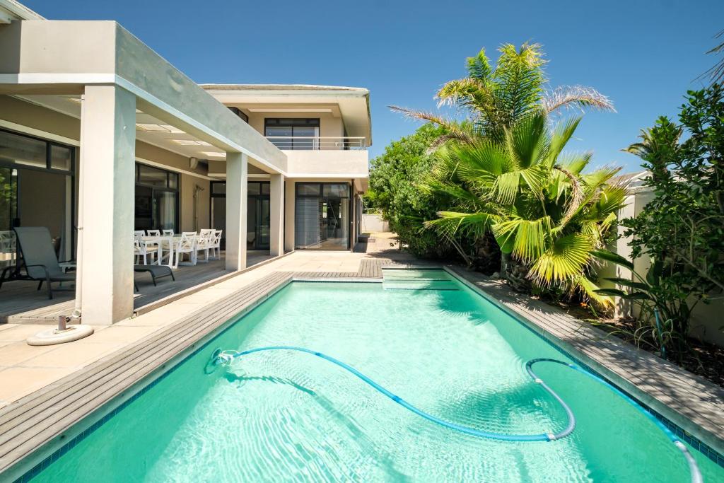 une piscine dans l'arrière-cour d'une maison dans l'établissement Belina - Sunset Links Golf Course Villa, au Cap