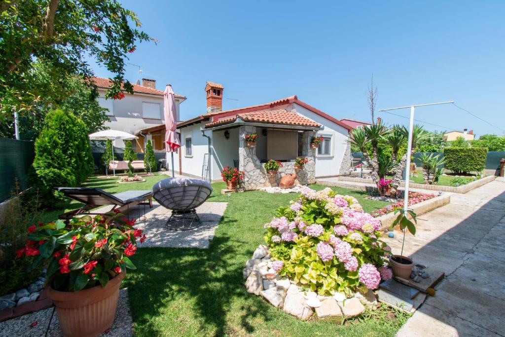 a yard with some flowers and a house at House Nicol Fazana in Fažana