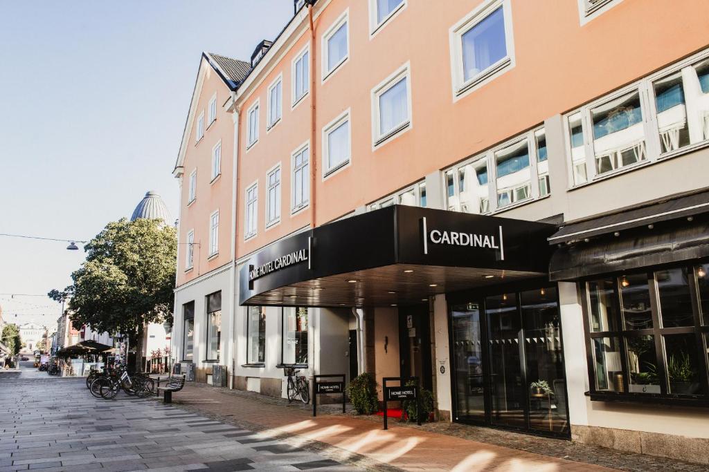 a building with a sign for a store on a street at Home Hotel Cardinal in Växjö