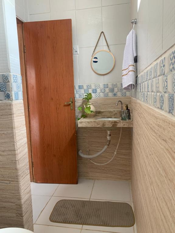 a bathroom with a sink and a wooden door at Pousada e Hostel Ponta de Campina in Cabedelo