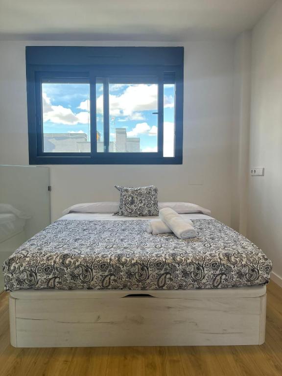 a bed in a bedroom with a window at A&R Atico Duplex Luxury II in San Sebastián de los Reyes