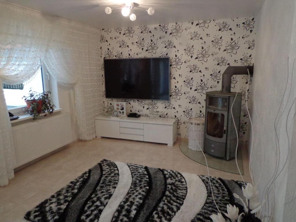 ein Schlafzimmer mit einem Fernseher an einer Wand mit Blumen in der Unterkunft Haus in der Nähe von Hannover Messe in Hannover