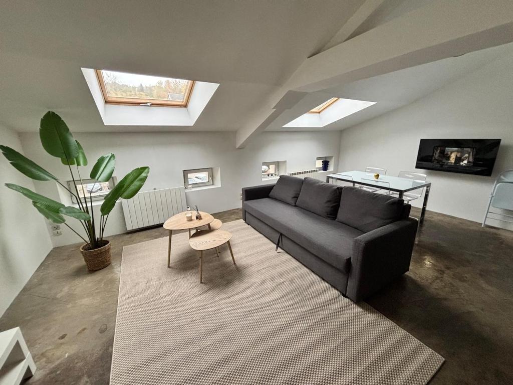 un soggiorno con un divano e un tavolo di Appartement loft proche frontières a Longlaville