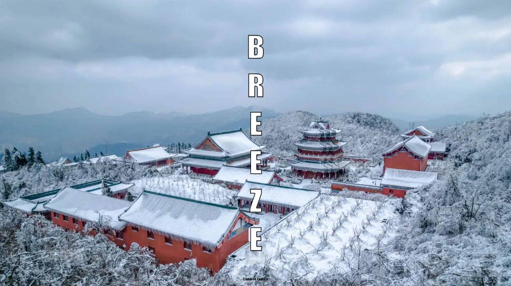 Breeze Alley Inn--English reception-Tourism planing-Ticket reservation في تشانغجياجيه: مجموعة مباني مغطاة بالثلج على جبل