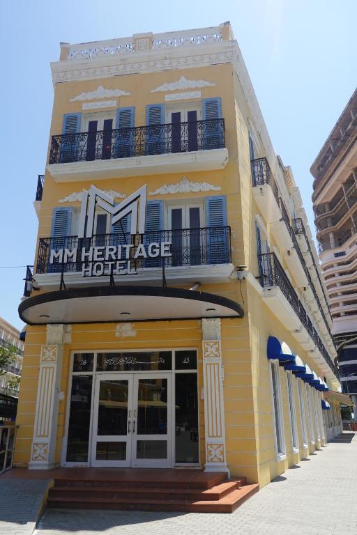 un bâtiment jaune avec un panneau d'hôtel dessus dans l'établissement MM Heritage Hotel, à Malacca