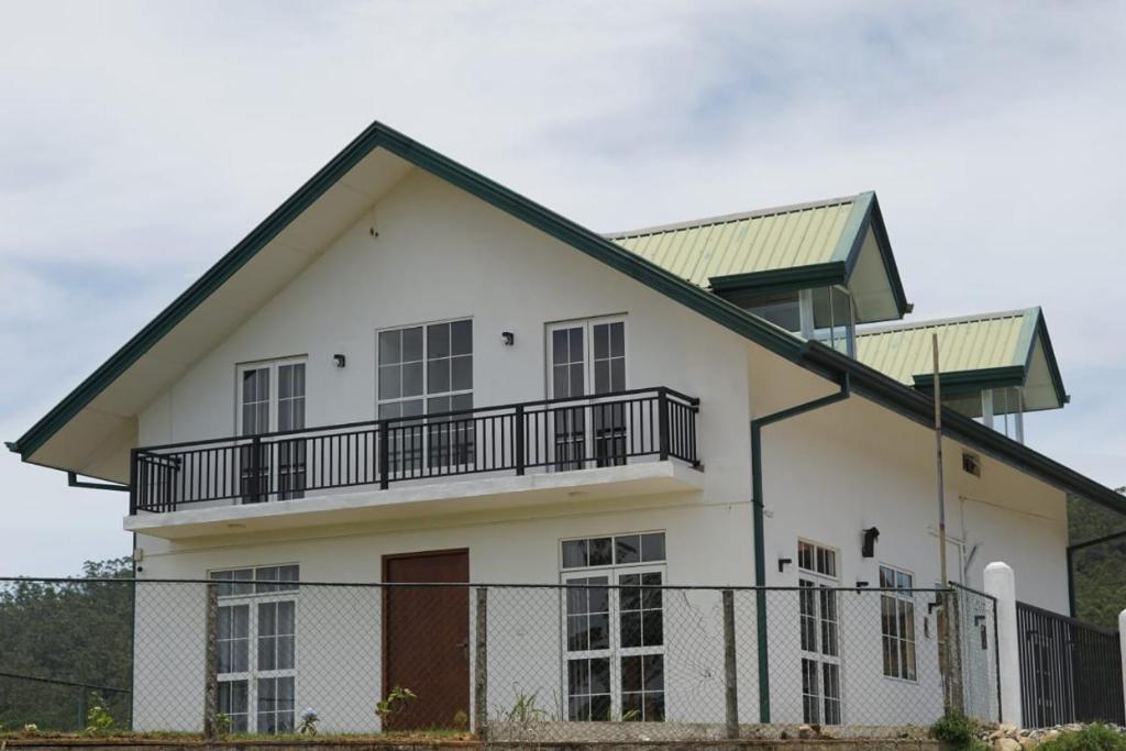 a white house with a black roof at Ivy Home in Nuwara Eliya