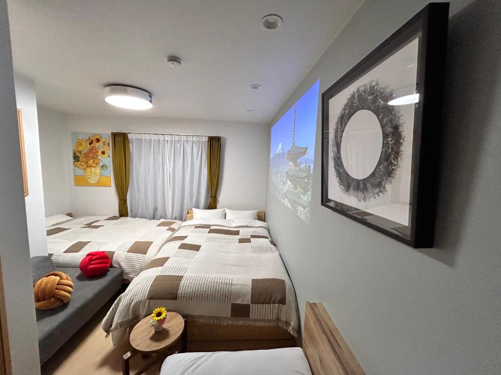 ein Hotelzimmer mit zwei Betten und einem Spiegel in der Unterkunft 77kawaramachi 新築一軒家 in Takamatsu