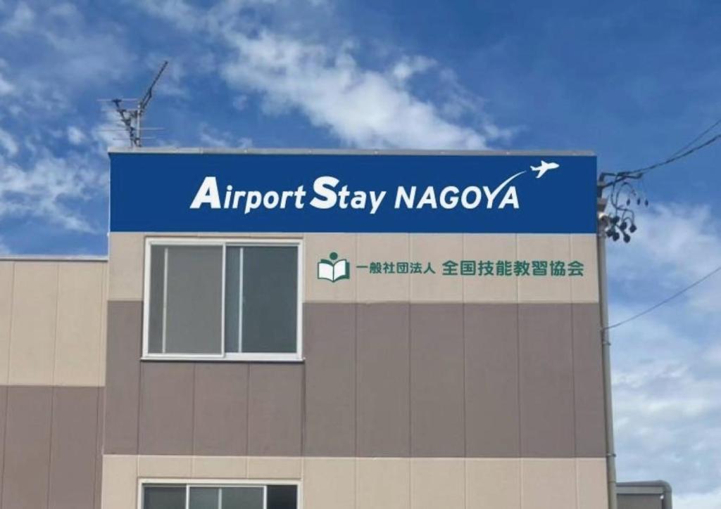 an airport stay naccaya sign on top of a building at Airport Stay Nagoya Men only guest house in Toyoyama