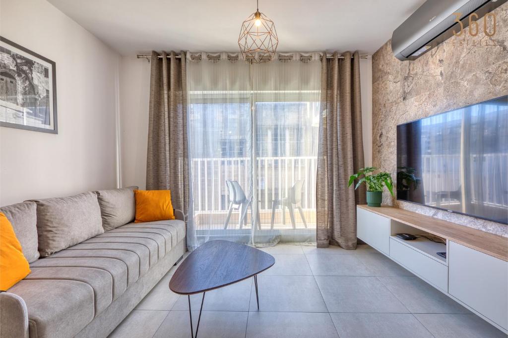 een woonkamer met een bank en een tv bij Central 2BR Home in Pieta's Heart with Wifi & AC by 360 Estates in Pieta