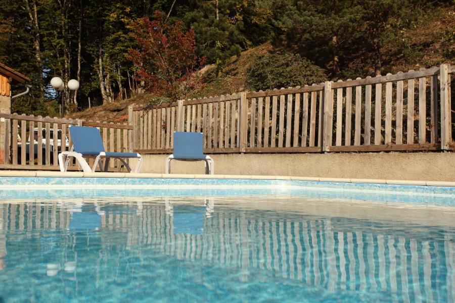 - deux chaises assises à côté de la piscine dans l'établissement Hotel Colombié, à Gorses