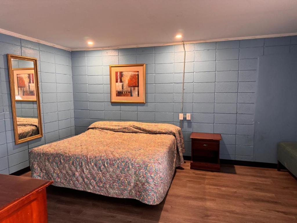 a bedroom with a bed and a blue wall at Walkers Inn by Hotel O Dothan US 84 in Dothan