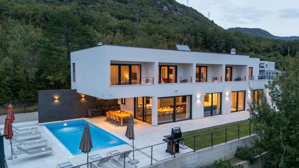 a house with a swimming pool in front of it at Villa Adria Blue in Bakarac