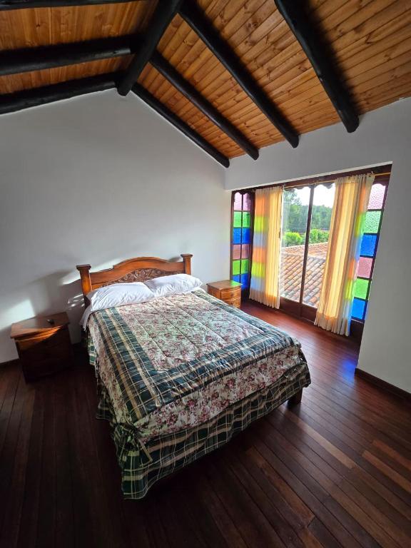 a bedroom with a bed with a colorful blanket at Hospedaje Casa Arte con Aroma de café in Duitama