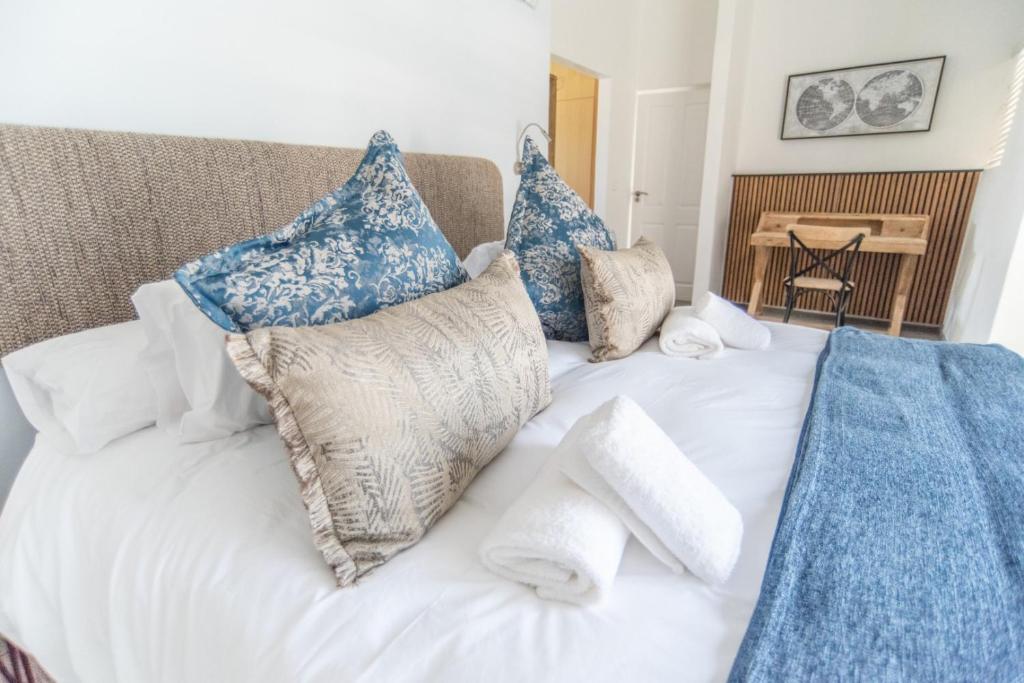 a bed with blue and white pillows on it at Waterfront Estate F13 Swakopmund in Swakopmund