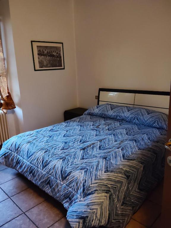 ein Bett mit einer blauen Bettdecke in einem Schlafzimmer in der Unterkunft Cusani 34 in Carate Brianza