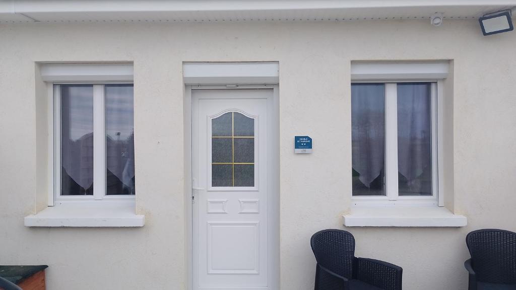 a white house with two windows and a door at gite en baie de somme in Cayeux-sur-Mer