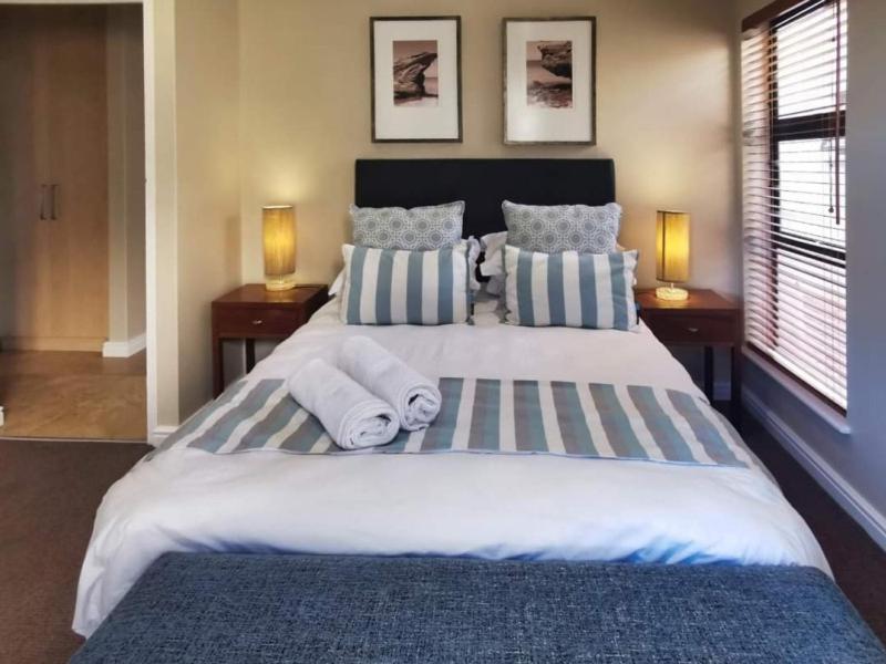 a bedroom with a large bed with towels on it at Langebaan Golf Suite in Langebaan