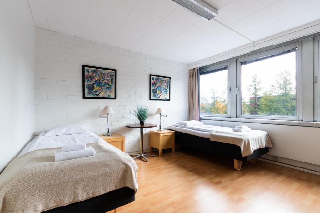 a bedroom with two beds and a window at Functional and cozy 3 bedroom apartment for 6 in Myyrmäki