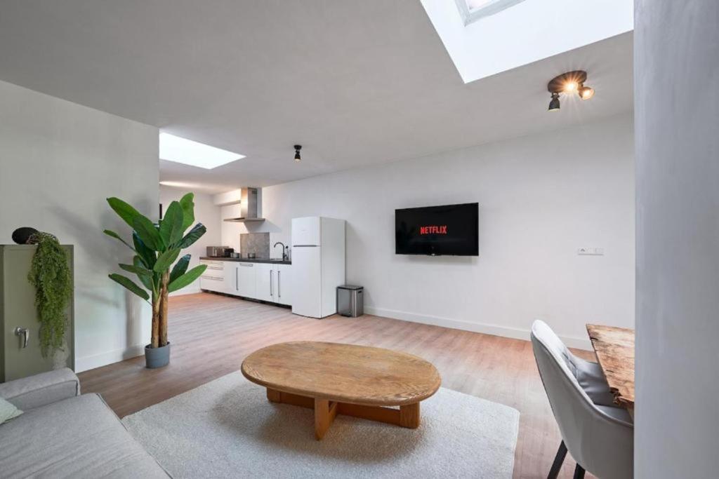 a white living room with a table and a couch at The Vault - Eindhoven - By T&S in Eindhoven