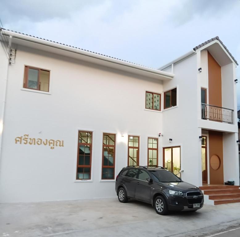 a black car parked in front of a white building at ศรีทองคูณ เชียงคาน ซอย4 in Chiang Khan