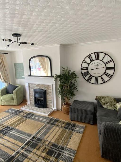 a living room with a clock and a fireplace at Beautiful 2 bed grd floor flat fantastic location in Eastbourne