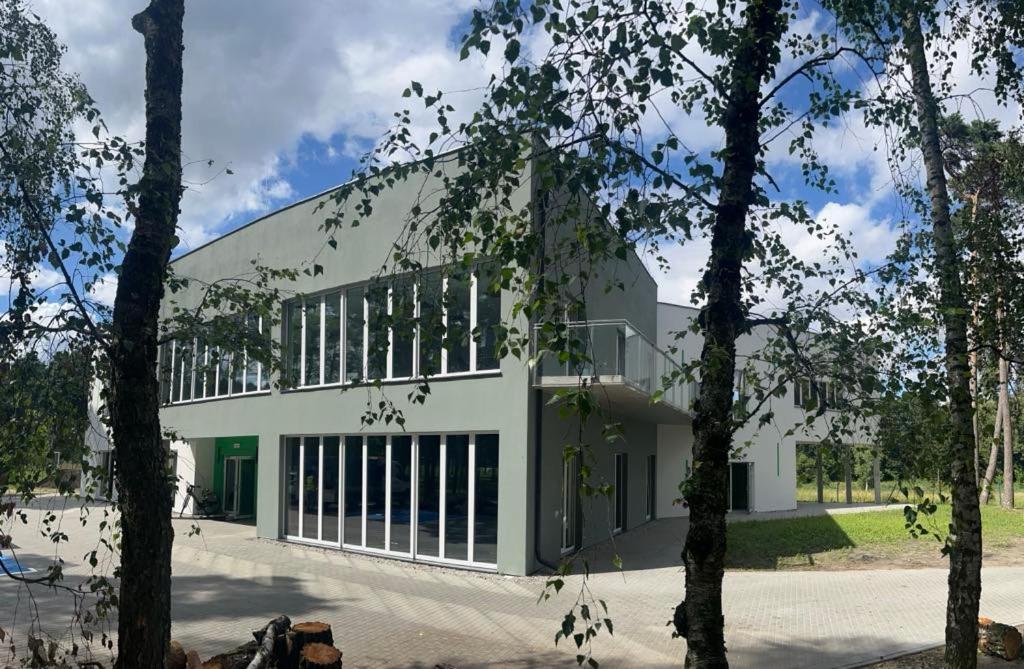 a large white building with windows and trees at Ośrodek Sportu i Rekreacji w Janowcu Wielkopolskim in Janowiec Wielkopolski