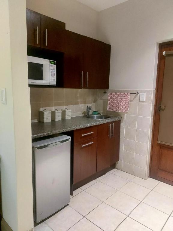 a small kitchen with a sink and a microwave at F19 Ocean View Villas in Port Edward
