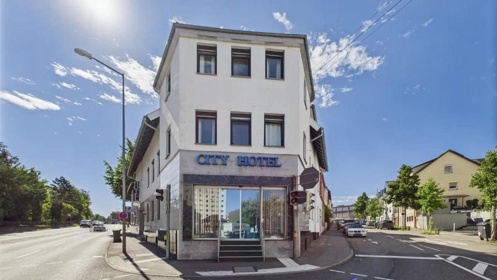 ルートヴィヒスブルクにあるシティ ホテルの市のサービスサインがある背の高い白い建物