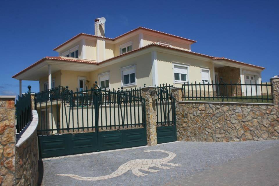 a house with a gate and a stone wall at Rancho Mar à Vista in Atalaia de Cima