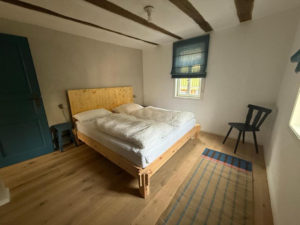 a bedroom with a bed and a chair in it at Zur Traube - blau in Erbach im Odenwald