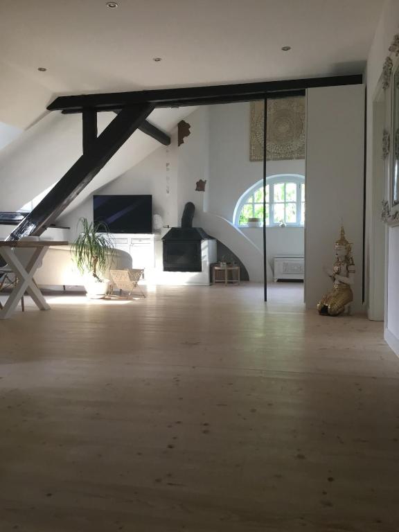 a large room with a wooden floor and a large window at Historisches Designer Loft Nähe Waldorfer Höfe in Ochtendung
