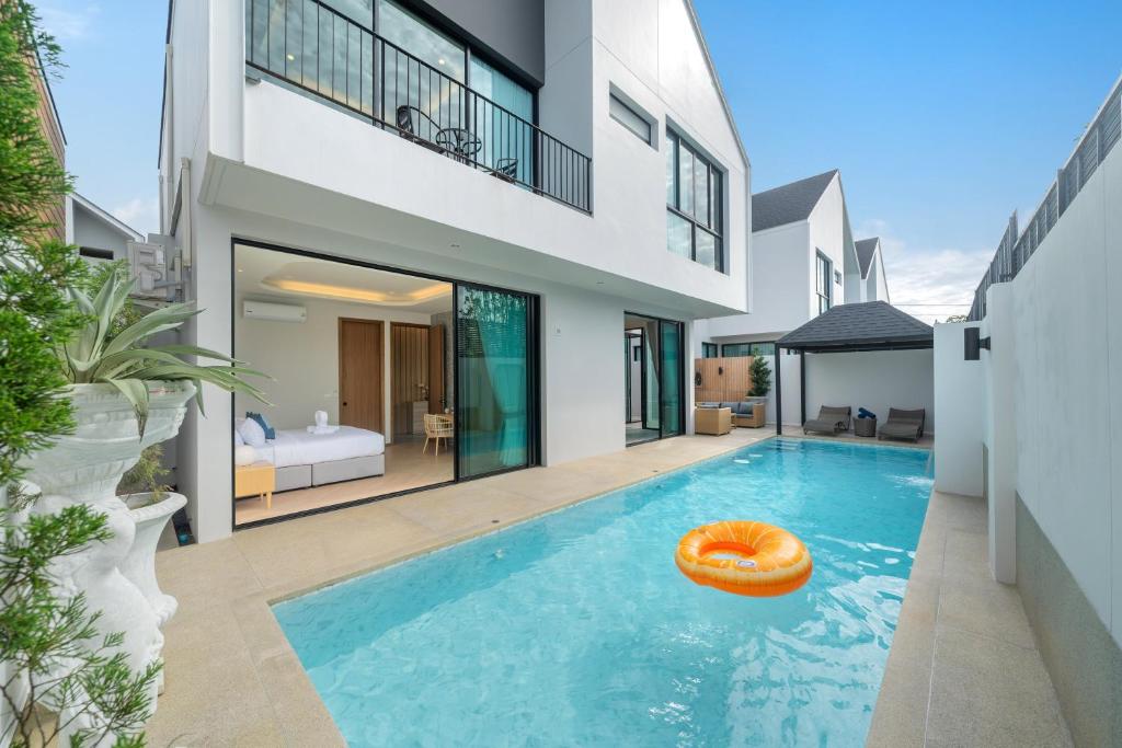 ein orangefarbener Rettungsring in einem Swimmingpool in einem Haus in der Unterkunft Bangtao Brand New Luxury Modern Pool Villa Laguna Phuket in Thalang
