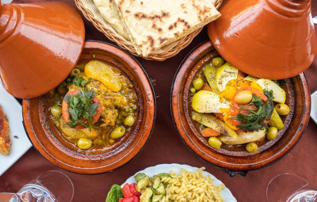 布马伦Hotel Atlas Gorge Dades的桌子上摆着三道菜和一壶果汁。