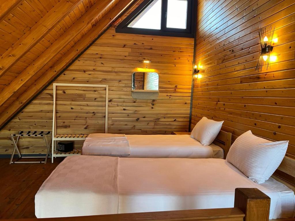 Un dormitorio con dos camas en una cabaña de madera. en Yeşilköy Bungalovs, en Silifke