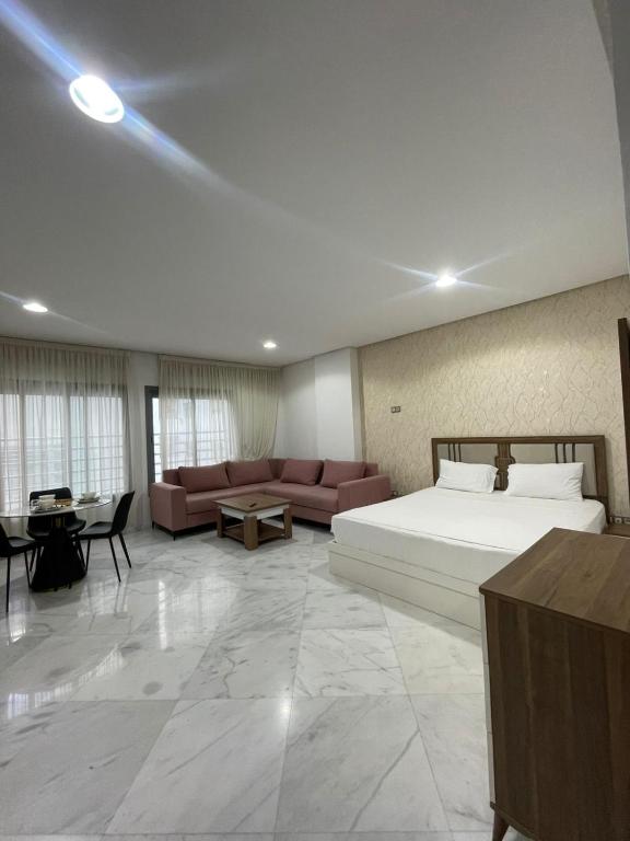 a bedroom with a bed and a couch and a table at Facelift in Tangier