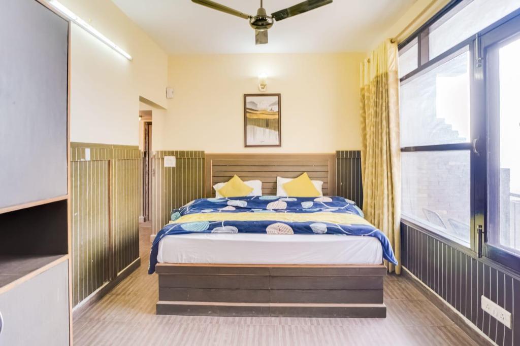 a bedroom with a bed and a large window at Kasauli Residency in Kasauli