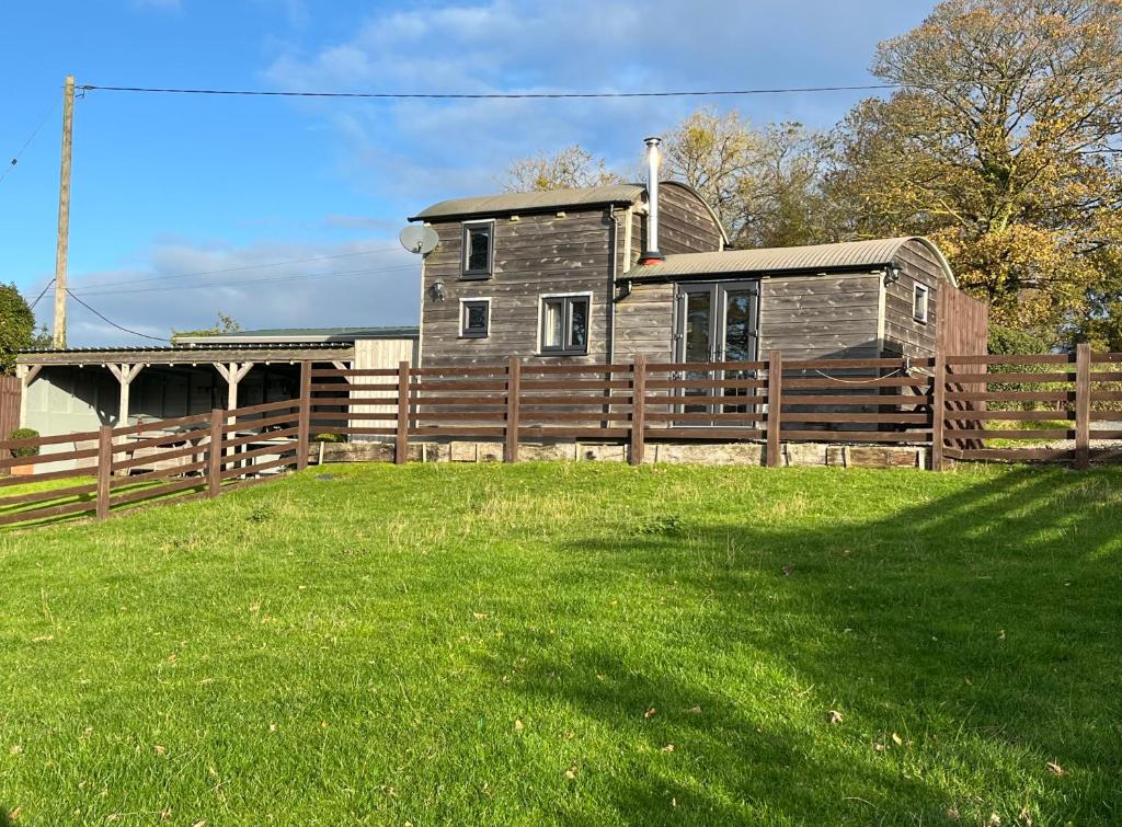 a wooden fence in front of a house at Shepherds Cabin at Titterstone in Farden