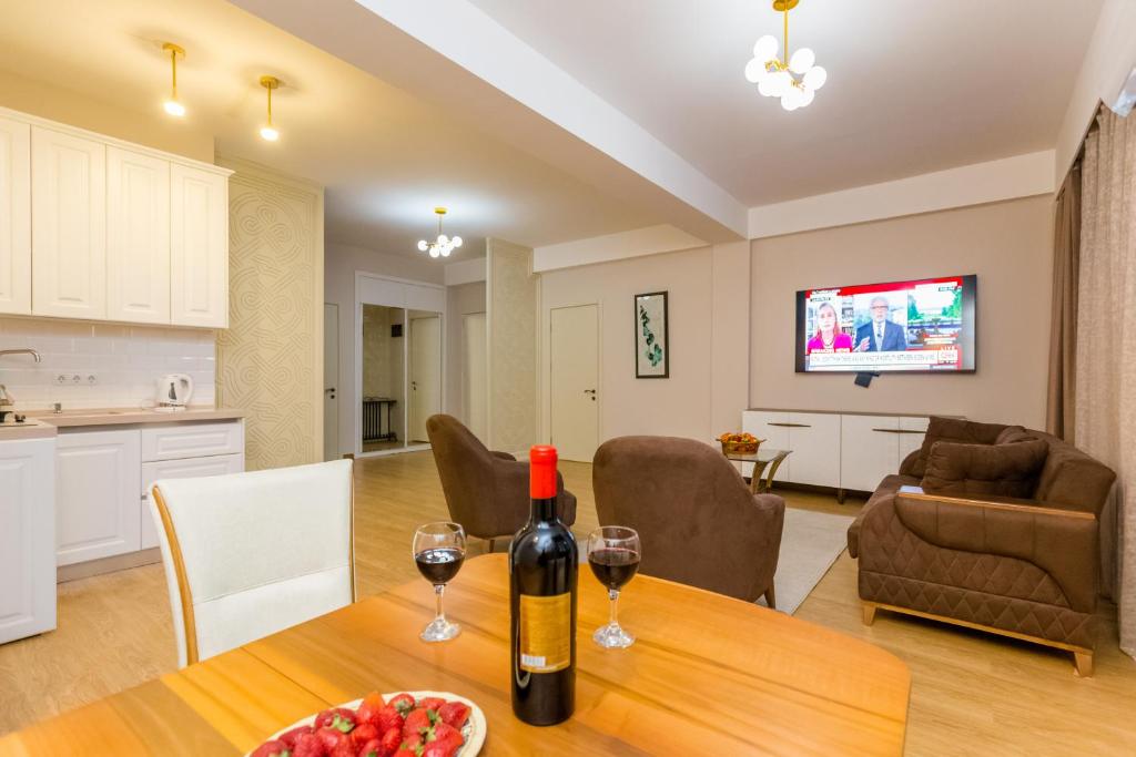 a living room with a table with two glasses of wine at Central Elegant Apartment in Tbilisi City
