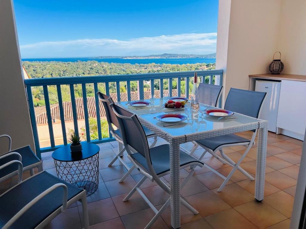 a dining room with a table and chairs on a balcony at Spacieux T2 Superbe vue mer in Grimaud