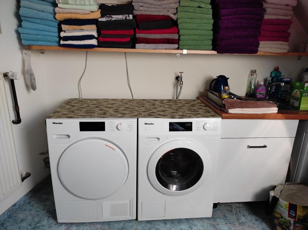 a laundry room with a washing machine and towels at Gästezimmer im Dachgeschoss in Rhede
