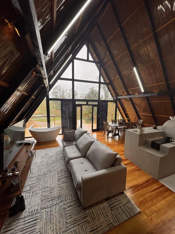 ItaquáにあるChalé de alto padrão Nereuのソファと大きな窓のあるリビングルーム