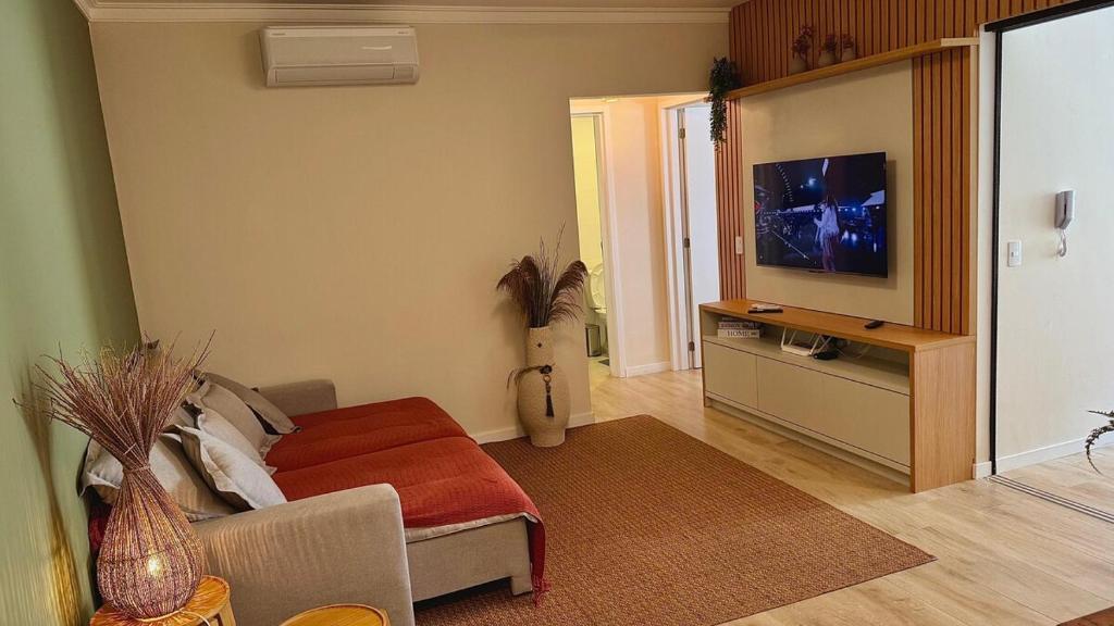 Una televisión o centro de entretenimiento en Piscina aquecida , ar, perto da praia, academia- DUO