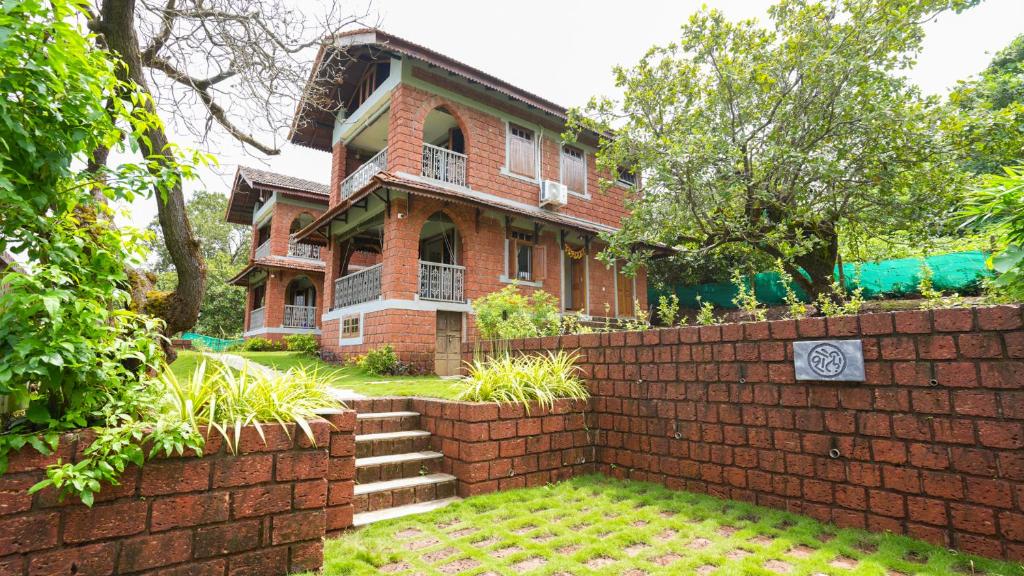 una casa di mattoni con un muro di mattoni di fronte di Shaili - 3BHK Konkani Villa near Tamastirth beach, Dapoli a Dapoli