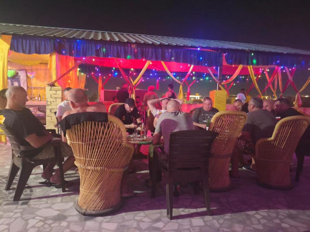 a group of people sitting at tables in a restaurant at Guesthouse Tofu- Fort View in Jaisalmer