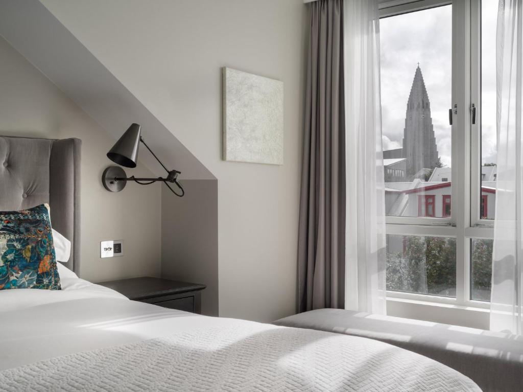 a bedroom with a bed and a window at Sand Hotel by Keahotels in Reykjavík