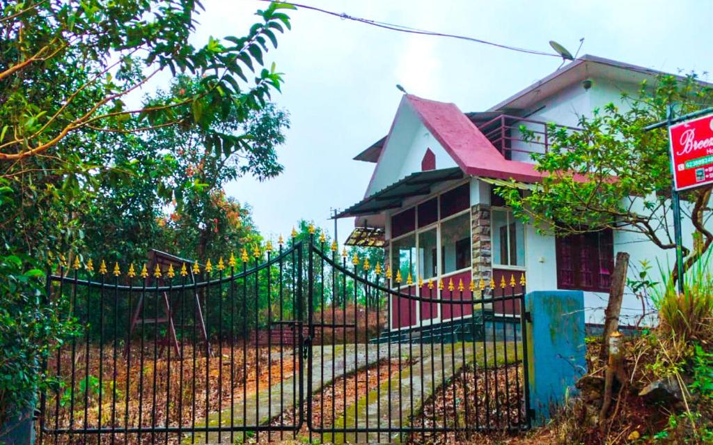 una casa con una valla negra delante en Breezeblow, en Vagamon