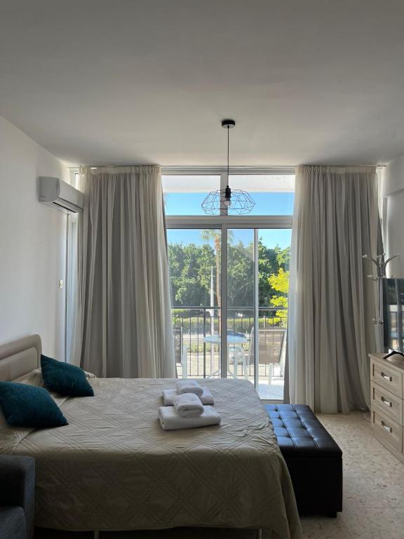 a bedroom with a bed and a large window at Almyria Apartments - By NOMA STAYS Cyprus in Paphos